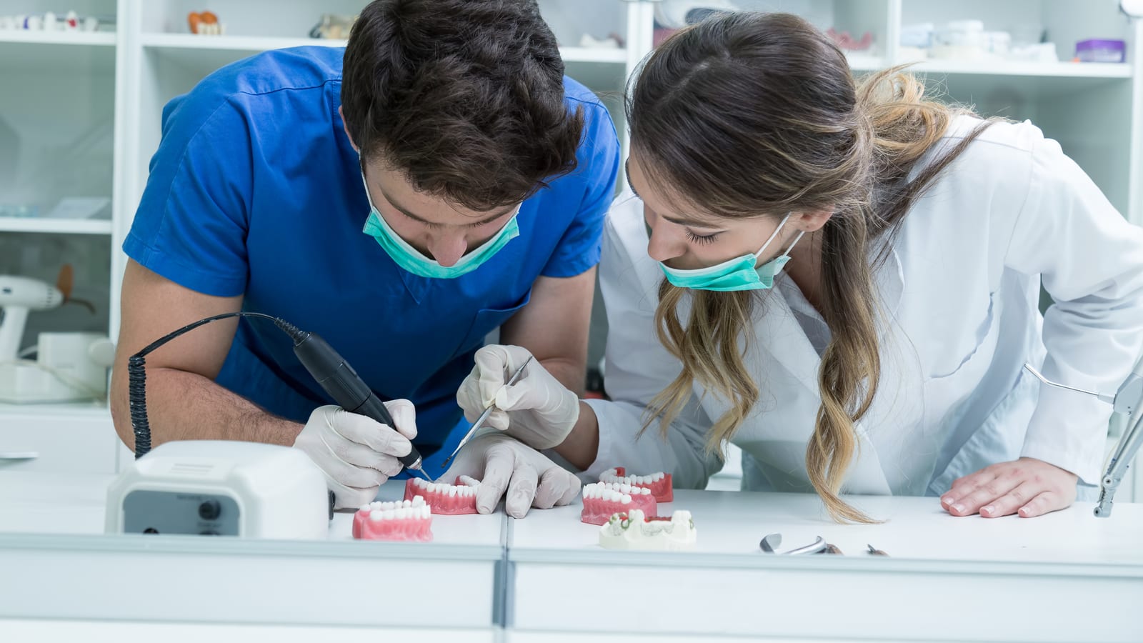 Two dental technicians working on a prosthetic